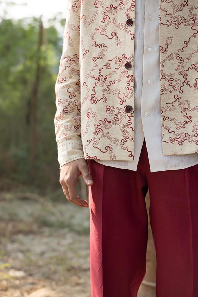A layered look featuring a Roger La Viale Tech Avant Garde shirt layered over a white linen shirt, styled with maroon trousers